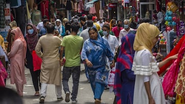 Kashmiris with and without protective face masks walk in a market before the upcoming Muslim festival Eid al-Adha in Srinagar. 