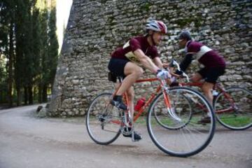 Dos ciclistas se cruzan junto a uno de los muros del Castillo de Brolio.