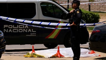 A Police officer stands near the body of former Ukrainian politician Andriy Portnov, at the spot where, according to the Spain's Interior Ministry, he was shot and killed by unidentified gunmen, outside a school, in Madrid, Spain May 21, 2025. REUTERS/Nacho Doce