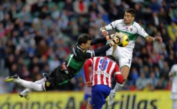 David Villa intenta rematar de cabeza ante Botía y el portero Manu Herrera.