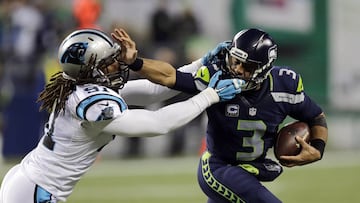 Seattle Seahawks quarterback Russell Wilson (3) pushes off of Carolina Panthers' Ryan Delaire as he runs with the ball in the first half of an NFL football game, Sunday, Dec. 4, 2016, in Seattle. (AP Photo/Stephen Brashear)