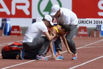 El atleta español Victor Garcia (centro) recibe asistencia tras tener que abandonar la prueba de los 3000m masculinos en los campeonatos de Europa de atletismo en el estadio Letzigrund en Zúrich