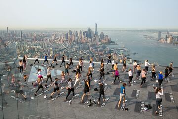 Un grupo de personas hace yoga en la azotea de un edificio de Manhattan (Nueva York). Como ocurre con muchos tipos de ejercicios al aire libre, esta práctica cogió gran demanda durante la pandemia del coronavirus, y no se ha pasado de moda, sino más bien al contrario: hay semanas de lista de espera para asistir a las clases.