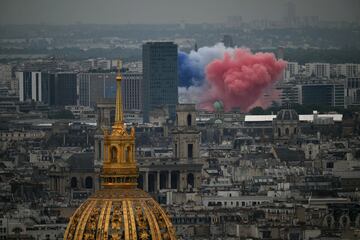 Vista general de la ciudad de París con una espectacular explosión de humo de colores que forma la bandera de Francia.