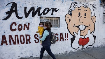 A woman carrying her baby walk past a mural promoting the April 10 recall referendum on the presidency of Mexican President Andres Manuel Lopez Obrador, in Mexico City, Mexico March 31, 2022. Picture taken March 31, 2022. REUTERS/Luis Cortes