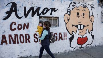 A woman carrying her baby walk past a mural promoting the April 10 recall referendum on the presidency of Mexican President Andres Manuel Lopez Obrador, in Mexico City, Mexico March 31, 2022. Picture taken March 31, 2022. REUTERS/Luis Cortes