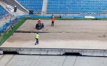 Operarios relizan diversas tareas en la instalación de butacas, vallas de vidrio y pantallas, así como cambios en la instalación de las bandejas del césped.