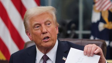 U.S. President Donald Trump holds up a letter from former President Joe Biden as he issues executive orders and pardons for January 6 defendants in the Oval Office at the White House on inauguration day in Washington, U.S., January 20, 2025. REUTERS/Carlos Barria TPX IMAGES OF THE DAY