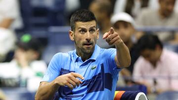 Novak Djokovic habla con su banquillo durante un partido del US Open.