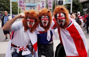 Londres muestra un gran ambiente en los aledaños del estadio de Wembley desde horas antes de que comience  la semifinal de la Eurocopa entre Inglaterra y Dinamarca. En la imagen, unos aficionados posan con gorros de león y la bandera de San Jorge pintada en sus rostros.