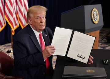 Signed | US President Donald Trump shows signed executive orders for economic relief.