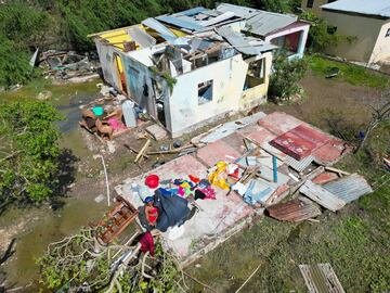 Una mujer recupera sus pertenencias de su casa después de que fuera azotada por el huracán Beryl en Portland Cottage, Clarendon, Jamaica.