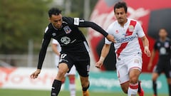 El jugador de Colo Colo, Gabriel Suazo, disputa el balón contra Carlos Espinosa de Curicó Unido durante el partido por Primera División.