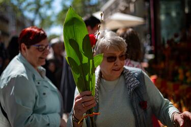 Transeúntes paseando con rosas, durante la Diada de Sant Jordi 2025.