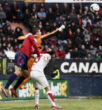 El portero del Sevilla Javi Varas despeja ante su compañero Coke y el jugador de Osasuna Oriol Riera.