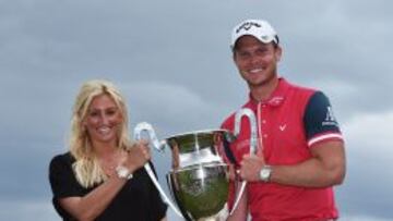 El inglés Danny Willett recibe su trofeo junto a su esposa, Nicole.