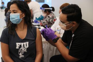 Camila Gutierrez, a junior at Florida International University, receives a Pfizer-BioNtech COVID-19 vaccine from Jason Rodriguez, a pharmacy student, at the Jackson Memorial Hospital on April 15, 2021 in Miami, Florida.