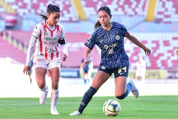 Scarlett Camberos conduce el balón mientras Lucía Muñoz la persigue para quitarle la esférica.