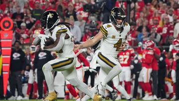 Oct 7, 2024; Kansas City, Missouri, USA; New Orleans Saints quarterback Derek Carr (4) hands off to running back Alvin Kamara (41) against the Kansas City Chiefs during the first half at GEHA Field at Arrowhead Stadium. Mandatory Credit: Denny Medley-Imagn Images