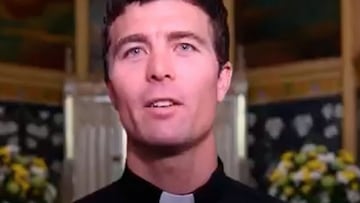 La cara del sacerdote y surfista P. Liam Ryan en la iglesia, con el organo y unas flores al fondo. 