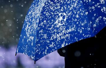 Paraguas de uos de los delegados de la UEFA que inspeccionan el terreno de juego.