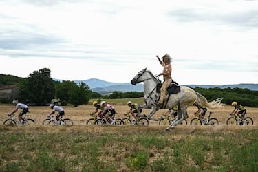 Un hombre a caballo cabalga junto al pelotón durante la 17.ª etapa de la 112.ª edición del Tour de Francia, en la etapa de 160,4 km entre Bollene y Valence, en el sur de Francia. 