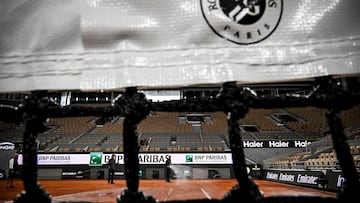 Employees spray water on the Court Philippe-Chatrier, a clay court, ahead of the French Open 2025 tennis tournament at the Roland Garros Complex, in Paris on May 21, 2025. (Photo by JULIEN DE ROSA / AFP)