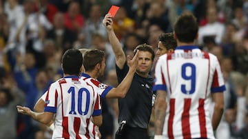 Referee Felix Brych shows a red card to Atletico's Arda Turan, left, during the second leg quarterfinal Champions League soccer match between Real Madrid and Atletico Madrid at Santiago Bernabeu stadium in Madrid, Spain, Wednesday, April 22, 2015. (AP Photo/Andres Kudacki)