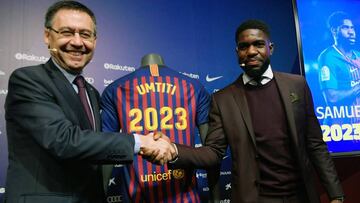 Football player Samuel Umtiti (R) shakes hands with the president of FC Barcelona Josep Maria Bartomeu during a press conference after Umtiti's renewal with the club at the Camp Nou stadium in Barcelona on June 4, 2018. / AFP PHOTO / LLUIS GENE