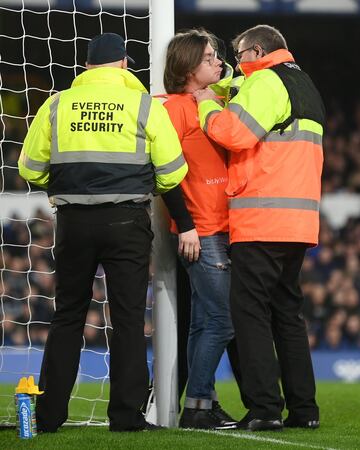 Ocurrió en el minuto 50 del Everton-Newcaslte. Un espectador, con una camiseta en la que se leía 'Just stop oil' se ha atado con una brida al poste. El partido estuvo parado durante siete minutos hasta que la seguridad del estadio del Everton consiguió romper la brida.