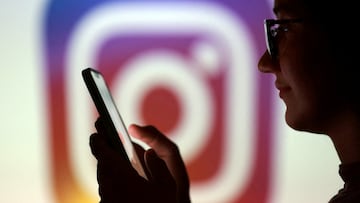 FILE PHOTO: A teenager poses for a photo while holding a smartphone in front of a Instagram logo in this illustration taken September 11, 2025. REUTERS/Dado Ruvic/Illustration/File Photo