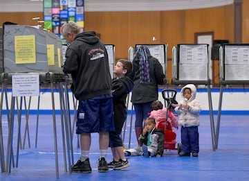 Daria Jones vota mientras sus hijos esperan en el Lewiston Memorial Armory, en el segundo distrito del Congreso de Maine.