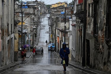 La gente camina por una calle bajo la lluvia antes de que el huracán Melissa tocara tierra, en Santiago de Cuba, Cuba.