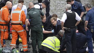 Conservative Member of Parliament Tobias Ellwood, centre, helps emergency services attend to an injured person outside the Houses of Parliament, London, Wednesday, March 22, 2017.  London police say they are treating a gun and knife incident at Britain&#039;s Parliament &quot;as a terrorist incident until we know otherwise.&quot; The Metropolitan Police says in a statement that the incident is ongoing. It is urging people to stay away from the area. Officials say a man with a knife attacked a police officer at Parliament and was shot by officers. Nearby, witnesses say a vehicle struck several people on the Westminster Bridge.  (Stefan Rousseau/PA via AP).