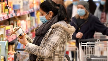 Customers wear face protection in a supermarket in Vienna on April 6, 2020. - As of today, April 6, 2020, it is mandatory in Austria to wear such protection in supermarkets with a sales area of 400 m2 or more. (Photo by ROLAND SCHLAGER / APA / AFP) / Aust