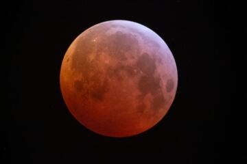 Se produce un eclipse lunar que ti?e de rojo la luna al pasar por la sombra terrestre. Se le conoce como superluna de sangre de lobo, ya que est¨¢ ligeramente m¨¢s cerca de la Tierra de lo normal.