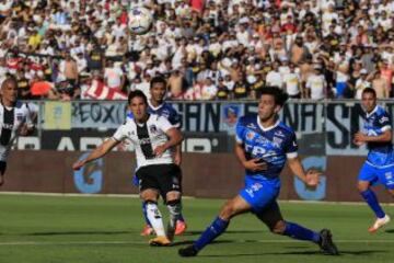 Juan Delgado busca la pelota ante Fernando Meza en el duelo de Colo Colo con San Marcos.