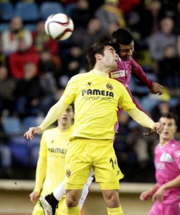 El centrocampista del Villarreal Trigueros (i) salta a por un balón con Navarrete, del Cádiz, durante el partido de vuelta de los dieciseisavos de final de la Copa del rey que disputan esta noche en el estadio de El Madrigal, en Villarreal. 