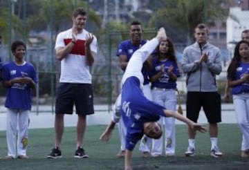 Jack Wilshere observa a uno de los bailarines de capeira.