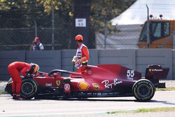 Carlos Sainz observa junto a un comisario de carrera el monoplaza siniestrado.