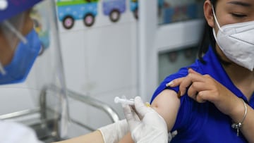 FILE PHOTO: A woman receives a vaccine as Vietnam starts its official rollout of AstraZeneca's coronavirus disease (COVID-19) vaccine for health workers, at Hai Duong Hospital for Tropical Diseases, Hai Duong province, Vietnam, March 8, 2021. REUTERS/Thanh Hue/File Photo