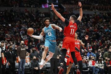 PORTLAND, OREGON - DECEMBER 17: Miles Bridges # 0 of the Charlotte Hornets looks to pass while defended by Larry Nance Jr. # 11 of the Portland Trail Blazers during the second half at Moda Center on December 17, 2021 in Portland, Oregon.