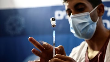 A nurse prepares a syringe to give a third dose of the covid-19 vaccine.