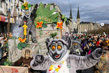 Personas vestidas con trajes tradicionales del carnaval Fritschi-Umzug asisten a un desfile para conmemorar el Jueves Gordo de Christian, en Lucerna, Suiza.