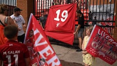 Liverpool fans hold a flag with the nuimber 19 for their 19th league title in celebration outside Anfield stadium in Liverpool, north west England on June 26, 2020 after Liverpool FC sealed the Premier League title. - Liverpool were crowned Premier League