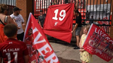 Liverpool fans hold a flag with the nuimber 19 for their 19th league title in celebration outside Anfield stadium in Liverpool, north west England on June 26, 2020 after Liverpool FC sealed the Premier League title. - Liverpool were crowned Premier League