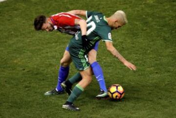 El centrocampista del Atlético de Madrid Saúl Ñíguez lucha el balón con Dani Ceballos, del Real Betis