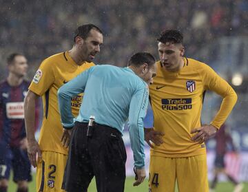 Godín y Giménez con el árbitro Mateu Lahoz.