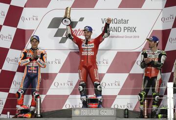 El piloto italiano Andrea Dovizioso celebra en el podio la victoria en el Gran Premio de Qatar junto al español Marc Márquez y el inglés Cal Crutchlow. 