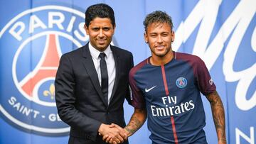 TOPSHOT - Brazilian superstar Neymar (R) shakes hands with Paris Saint Germain's (PSG) Qatari president Nasser Al-Khelaifi during a press conference at the Parc des Princes